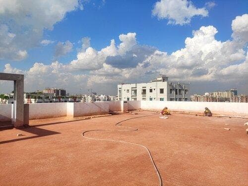 Workers preparing a large residential terrace for waterproofing