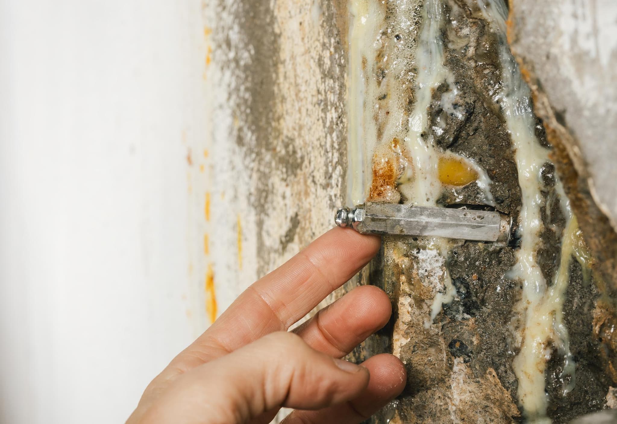Injection packer installed in a wall crack with resin sealant